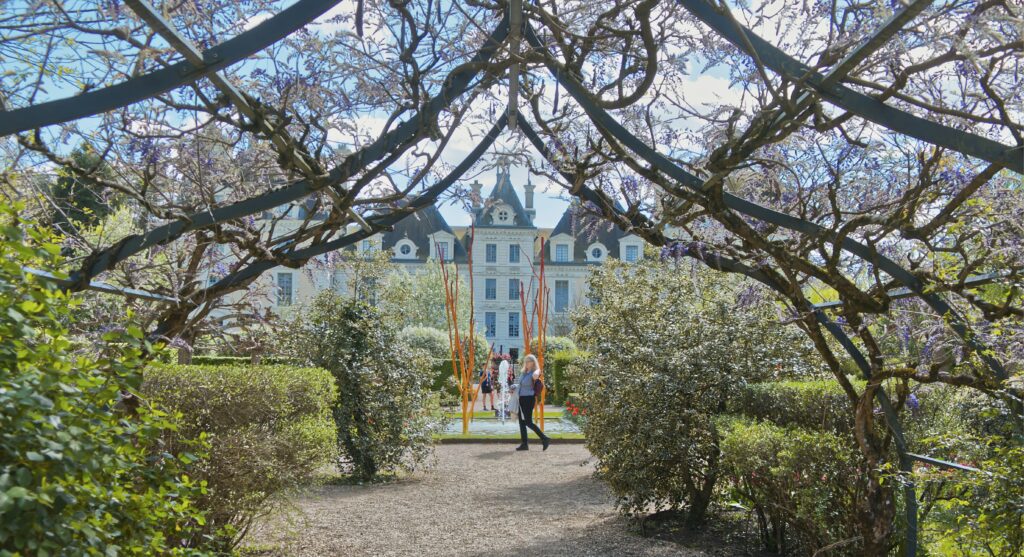 A woman takes a stroll through the romantic gardens of a large estate in France's Loire Valley. Romantic getaway. Loire Valley honeymoons.