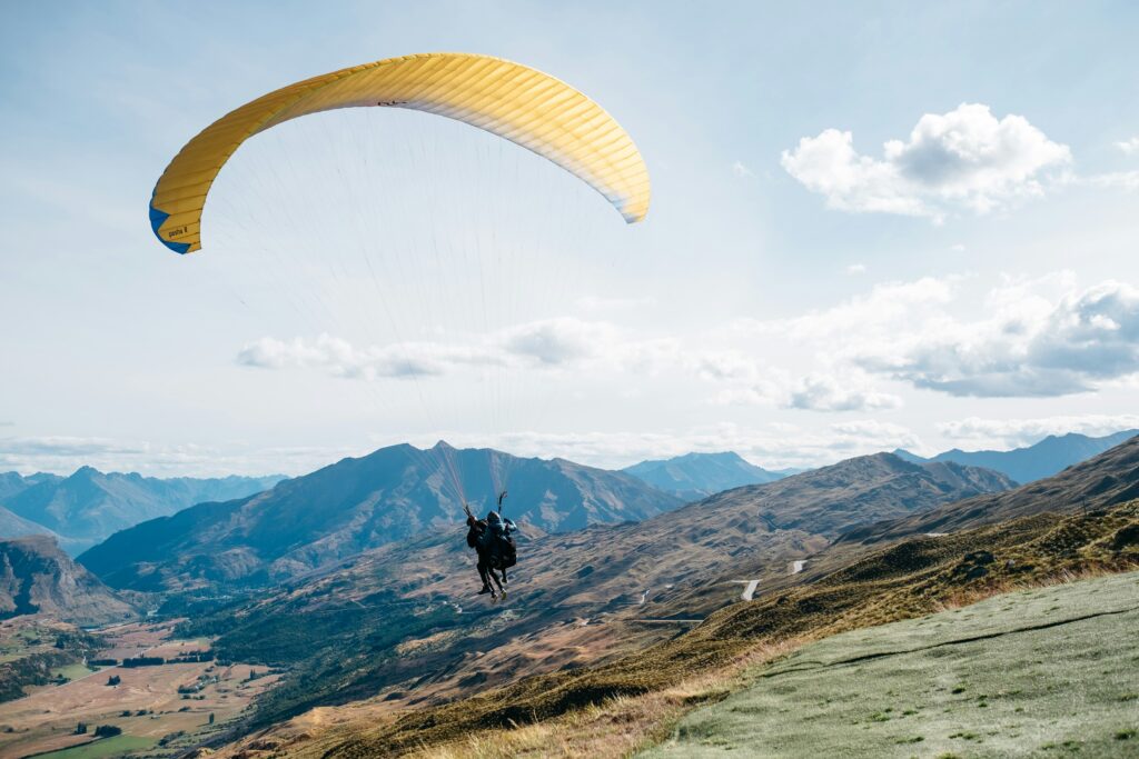 Couple enjoys hang gliding in New Zealand. Allegro Luxury Vacations. Romantic getaway. Brenda Ajay, Virtuoso luxury travel specialist.