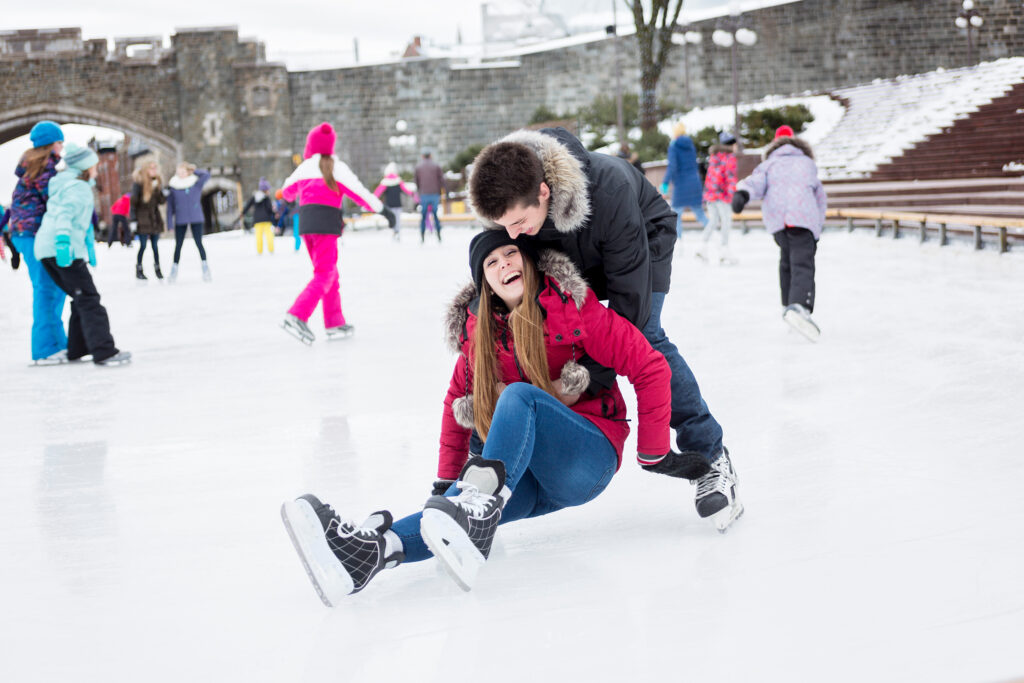 An Ice skating couple having winter fun on ice skates Quebec, Canada. Allegro Luxury Vacations. Romantic getaway. Brenda Ajay, Virtuoso luxury travel specialist.