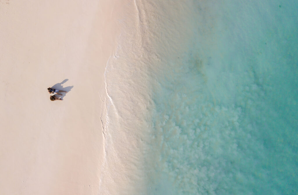 View from above of a couple standing on a sandy beach in Zanzibar. Romantic getaway. Allegro Luxury Vacations, BRenda Ajay, travel specialist