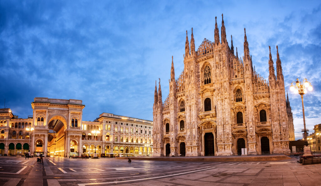 First trip to Italy tips. Travel Takes longer than it looks. Evening view of Milan’s Piazza del Duomo with the ornate cathedral and historic Galleria Vittorio Emanuele II
