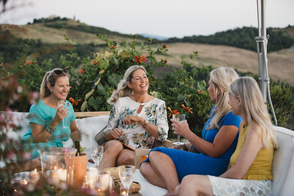 Friends enjoying wine overlooking the vineyards in Italy